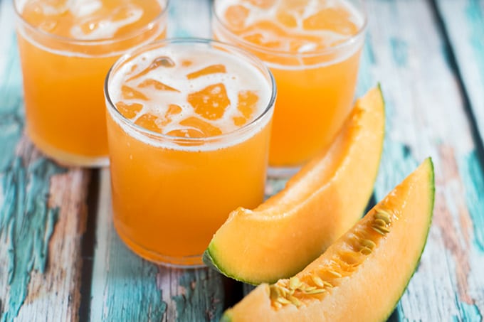 three glasses filled with fresh cantaloupe juice.