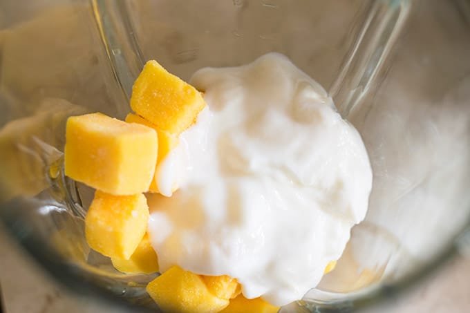 frozen mango cubes and yogurt in a blender