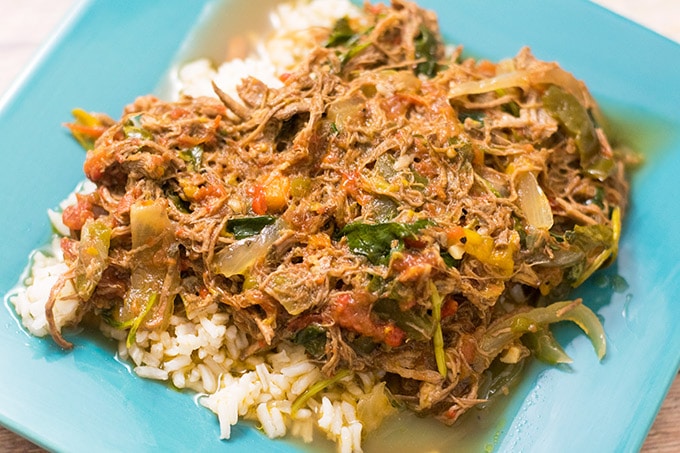 ropa vieja over rice on a blue plate