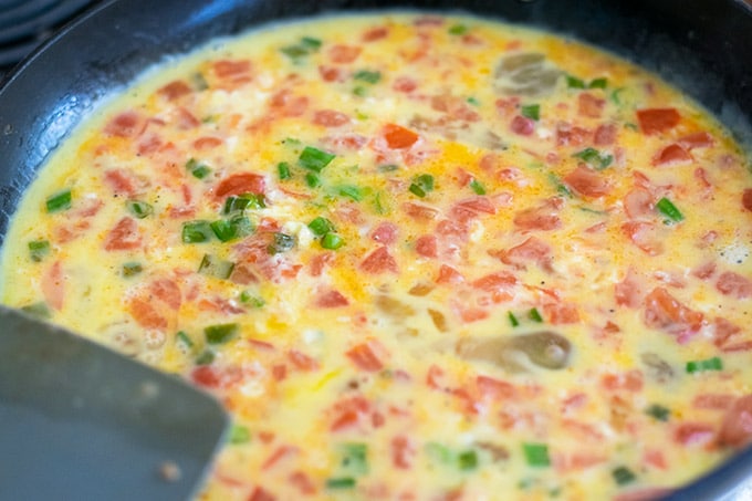 tomatoes, green onions and eggs in a skillet