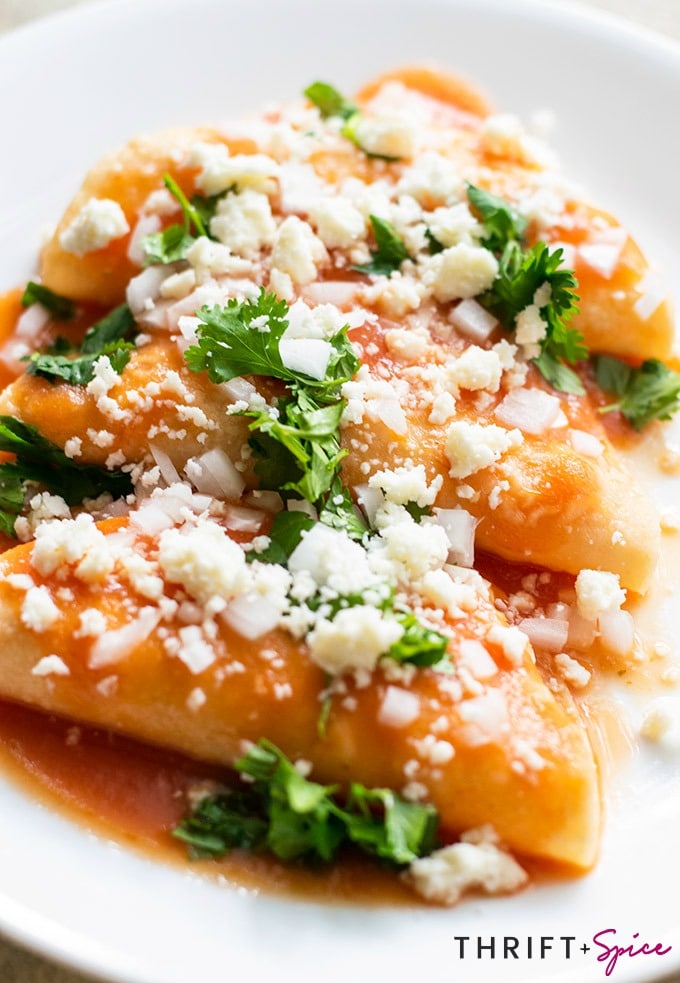 entomatadas garnished with onion, cilantro and queso fresco