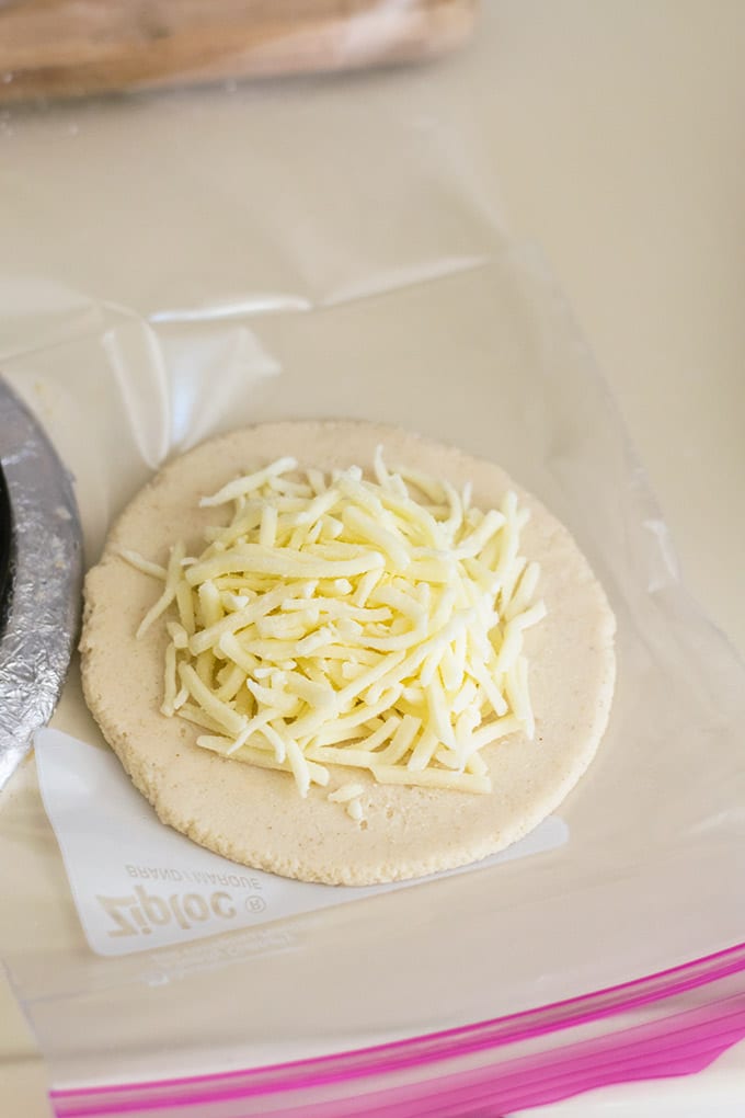 mozzarella cheese on top of flattened dough 