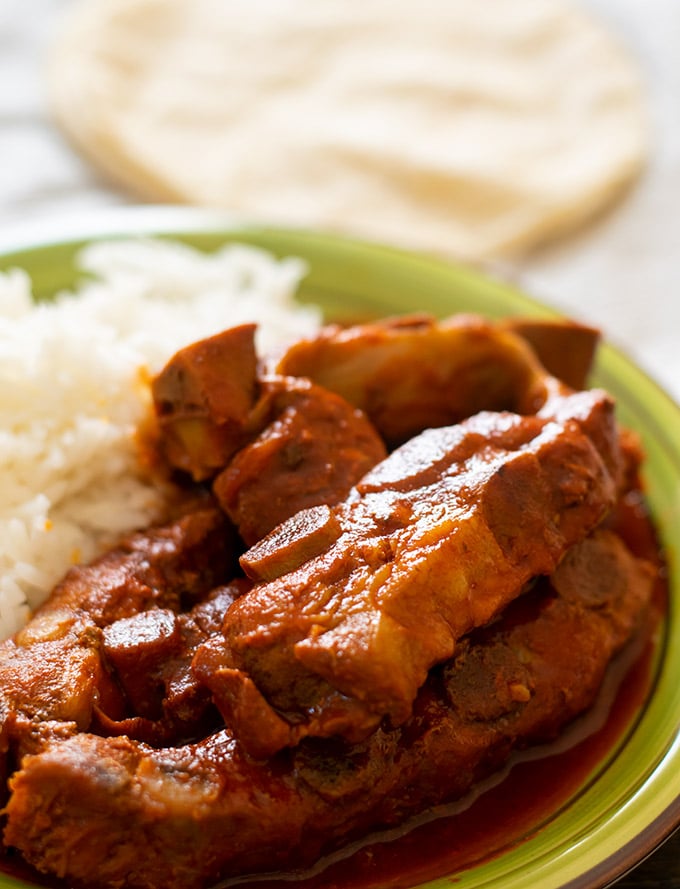 costillas de puerco and white rice on a green plate