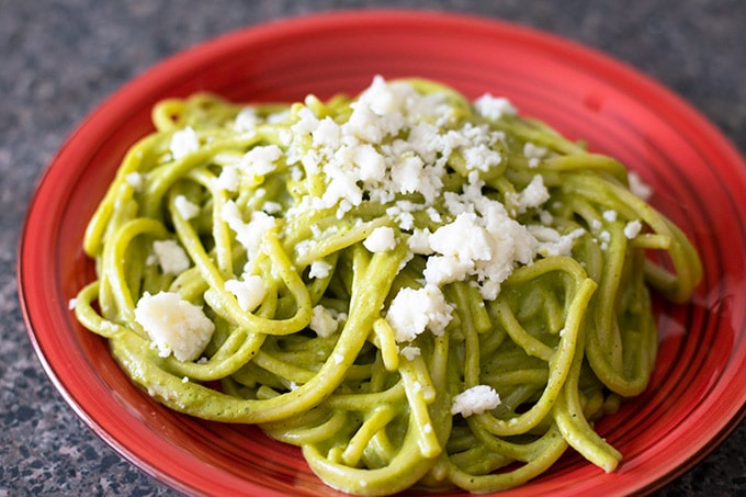 espagueti verde (green spaghetti) on a red plate