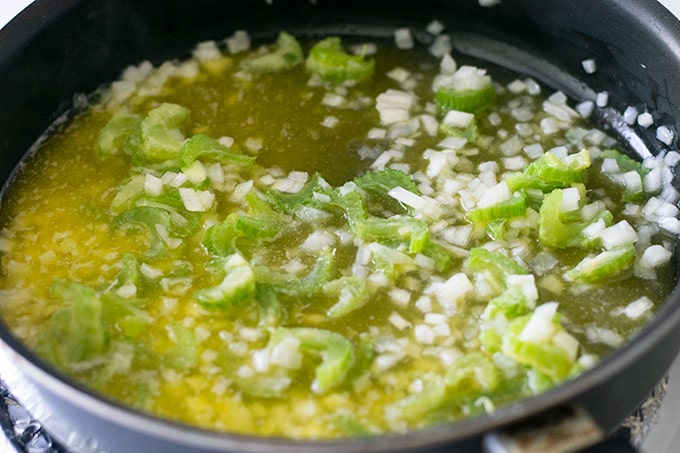 onion and celery in a pot with melted butter