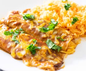 tex mex cheese enchiladas served with rice and garnished with cilantro