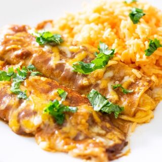 tex mex cheese enchiladas served with rice and garnished with cilantro