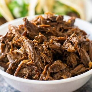 Beef barbacoa in a white bowl.