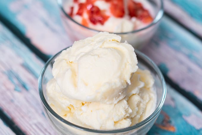 homemade vanilla ice cream in bowls one topped with strawberries