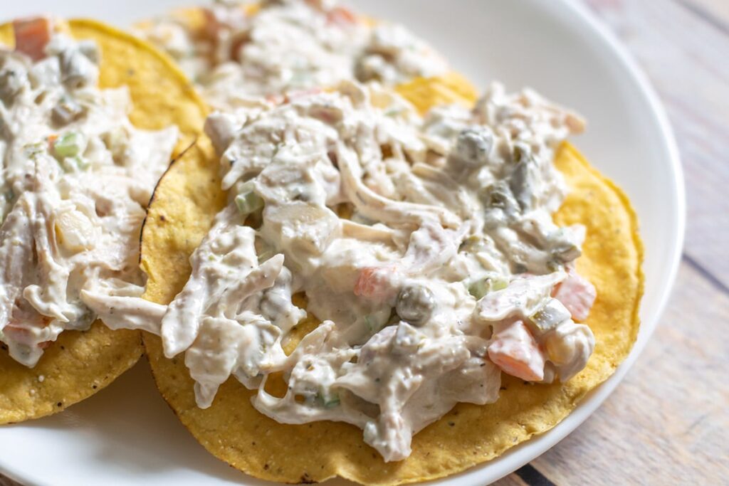 Mexican chicken salad tostadas on a white plate.