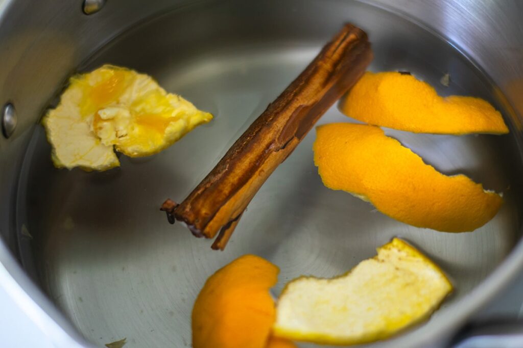 orange peel and a cinnamon stick in a pot of water