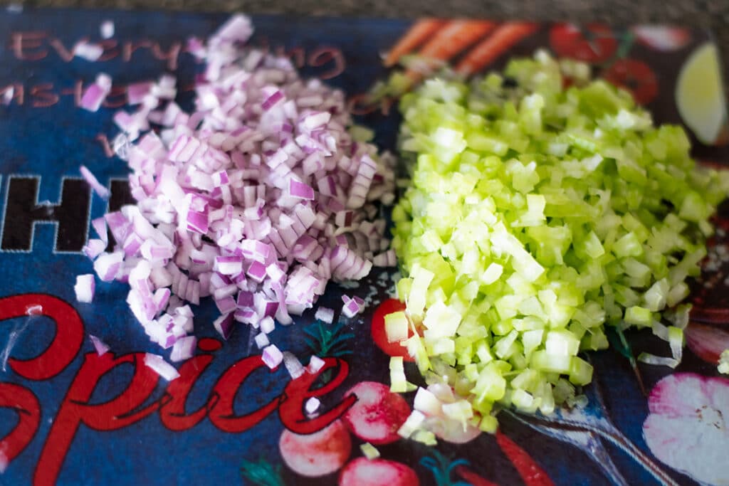 chopped red onion and celery on a cutting board