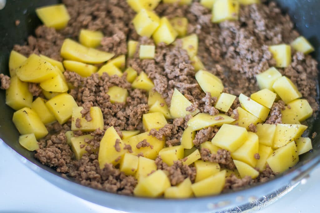 ground beef and diced potatoes in a skillet