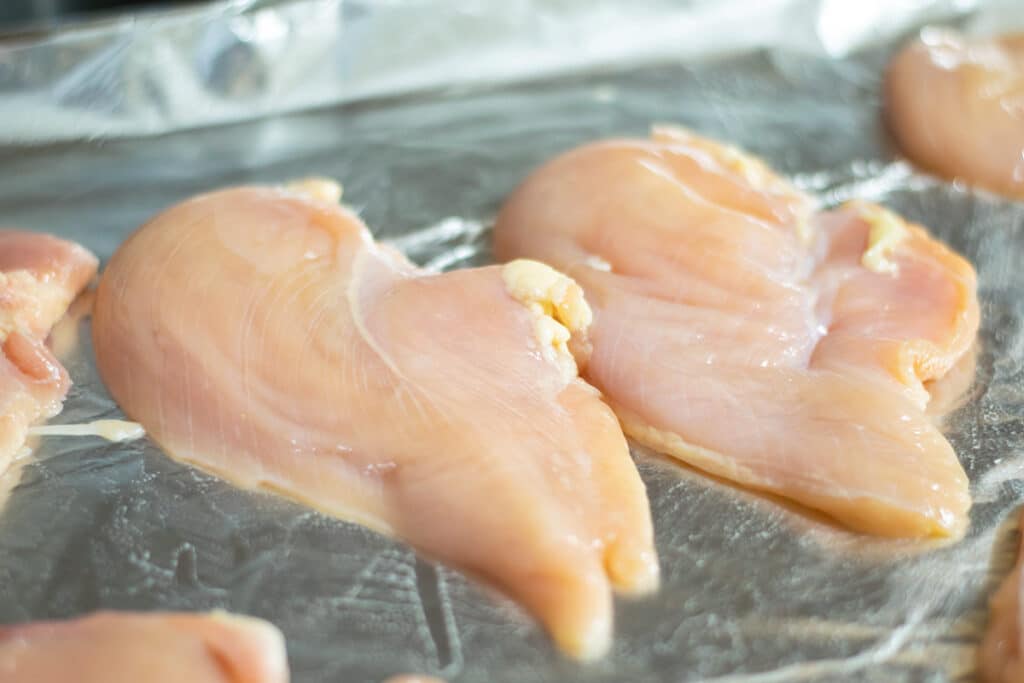 chicken cutlets on a foil lined baking sheet
