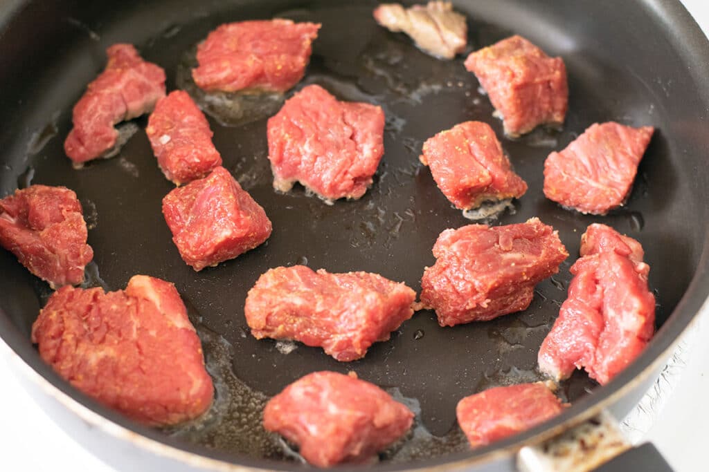 Stew meat in a skillet.