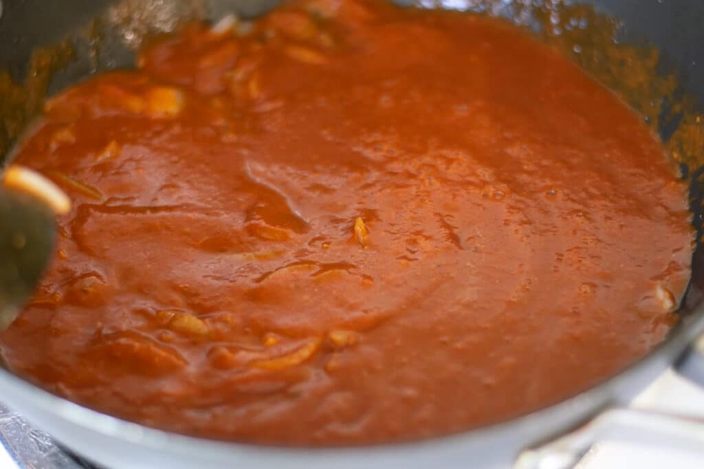 cooking tomato sauce in a skillet.