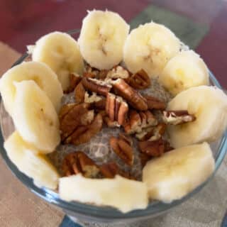 chia pudding with oat milk and garnished with pecans and banana.