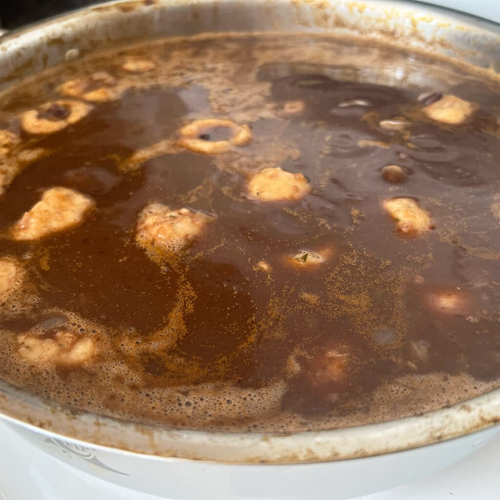 Black bean soup with bolitas de masa in a pot.