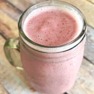 A glass of strawberry oat milk smoothie.