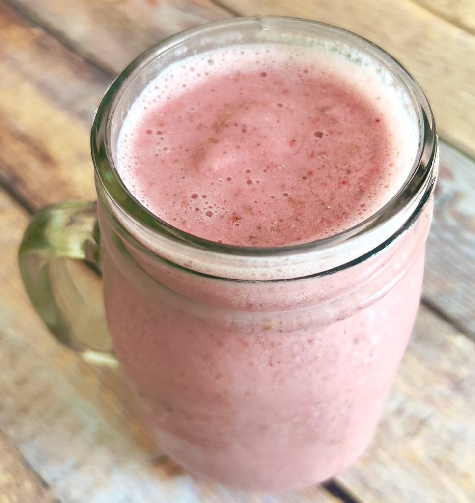 A glass of strawberry oat milk smoothie.