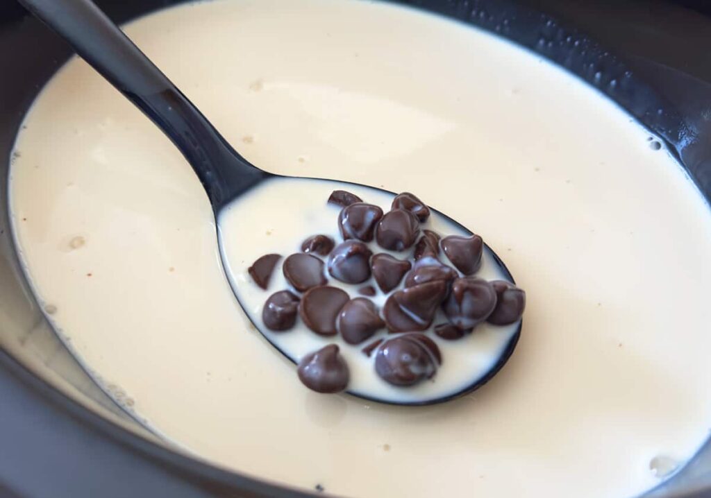 Chocolate chips and milk in a slow cooker.