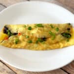 Omelet with black beans on a white plate.