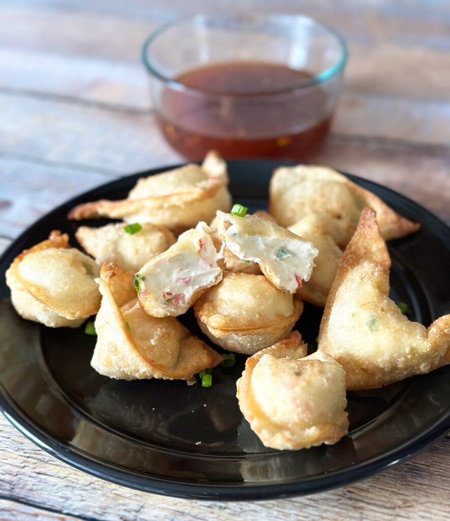 Cream cheese wontons on a black plate