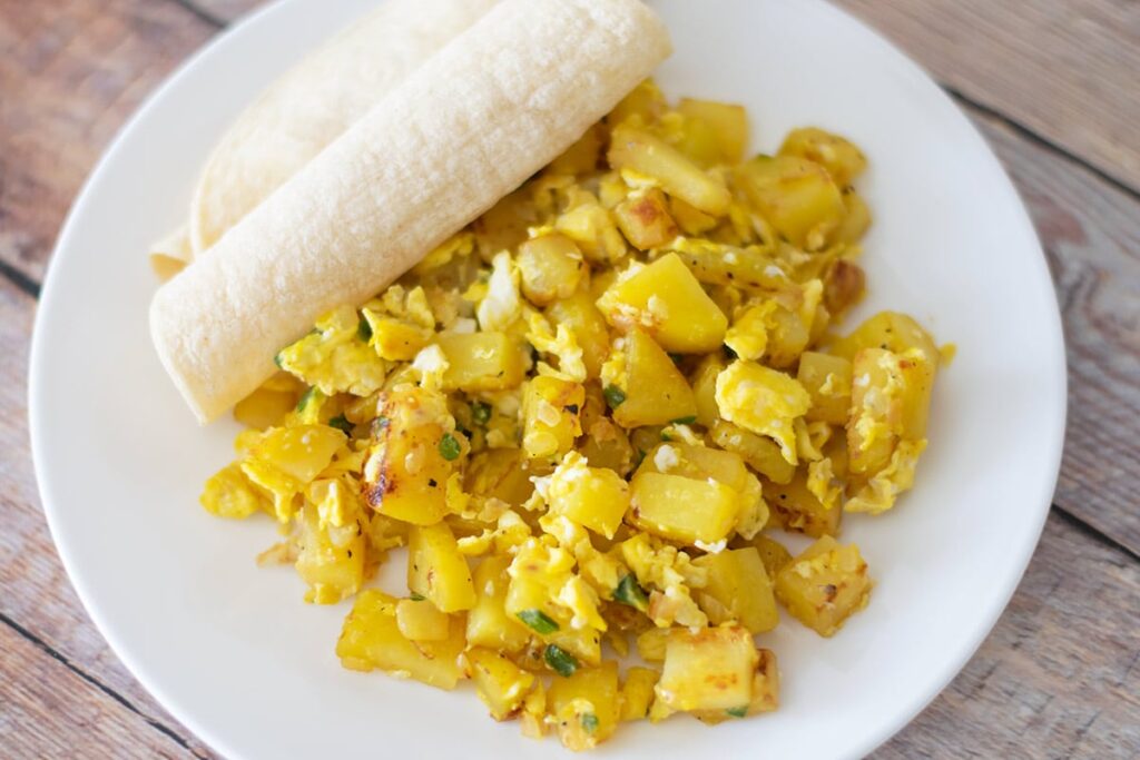 Mexican potatoes and scrambled eggs on a plate.