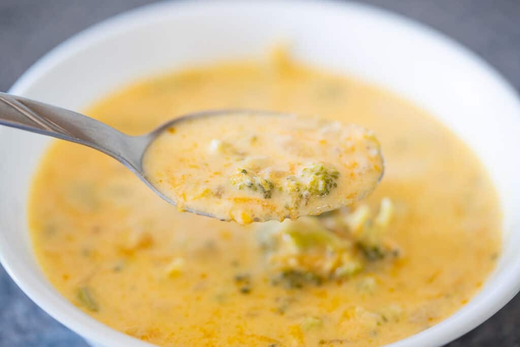 Brocolli and cheddar soup in a white bowl.