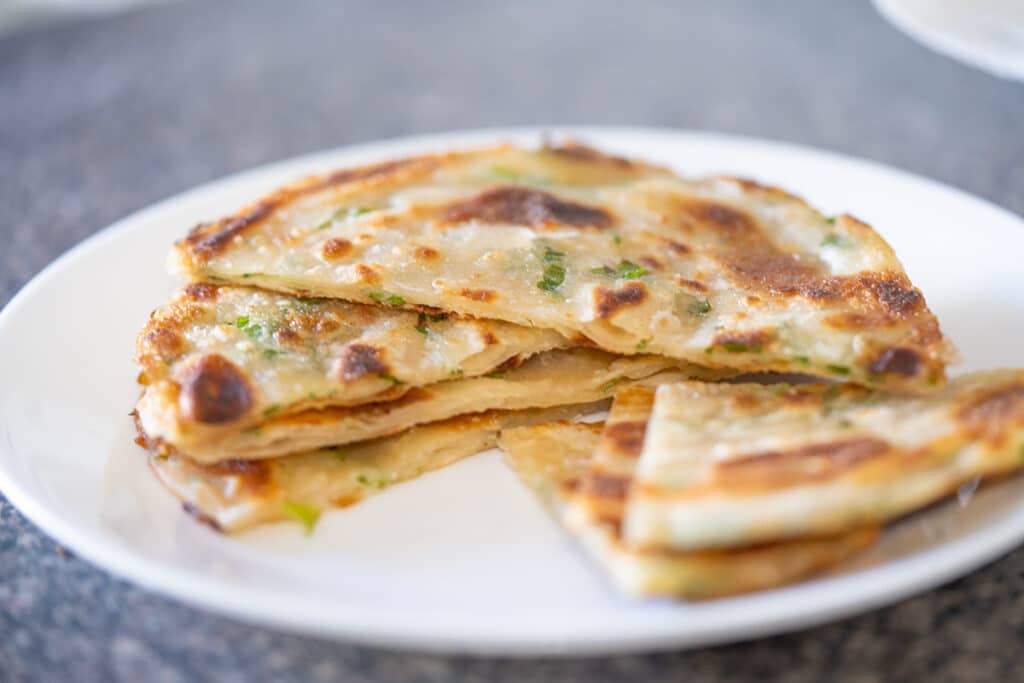 Scallion pancakes on a white plate.