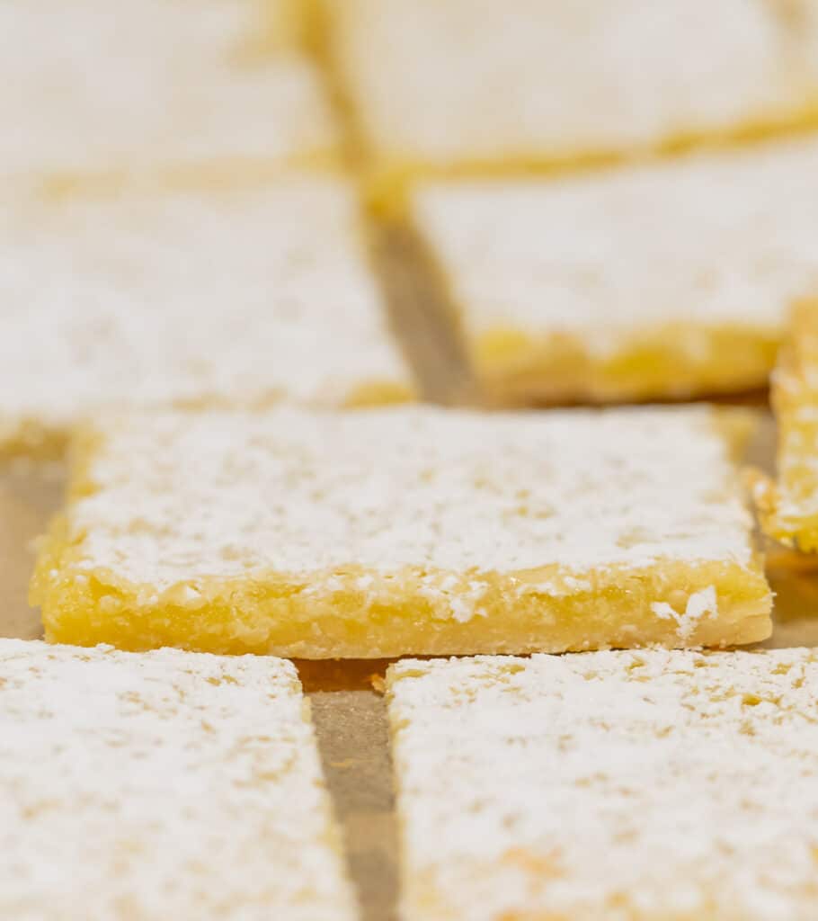 Thin lemon squares on a baking sheet.