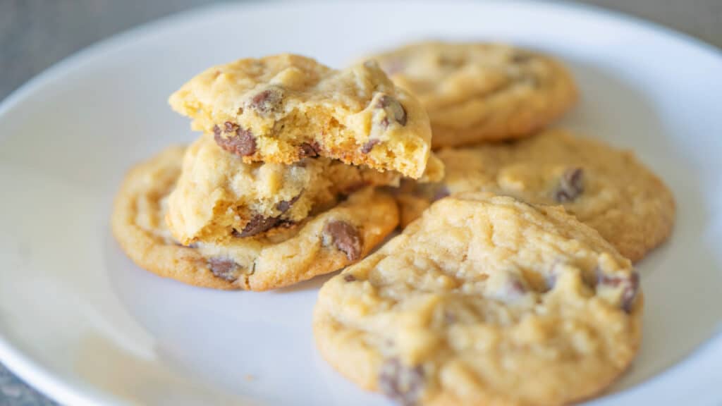 Chocolate chip cookies on a white plate.