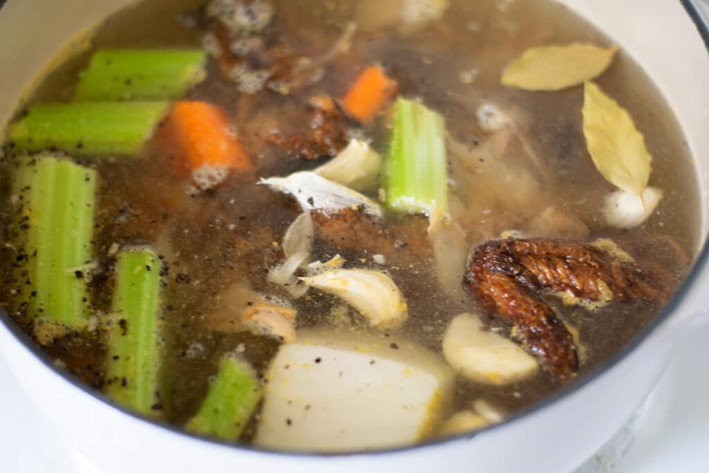 Ingredients for homemade chicken bone broth in a pot.