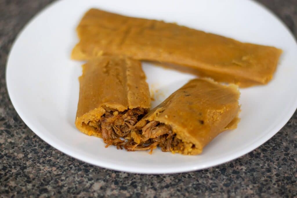 Beef tamales on a white plate.
