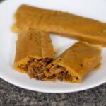 Beef tamales on a white plate.