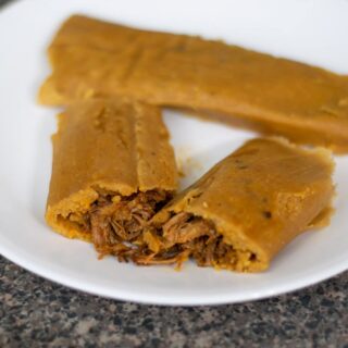 Beef tamales on a white plate.