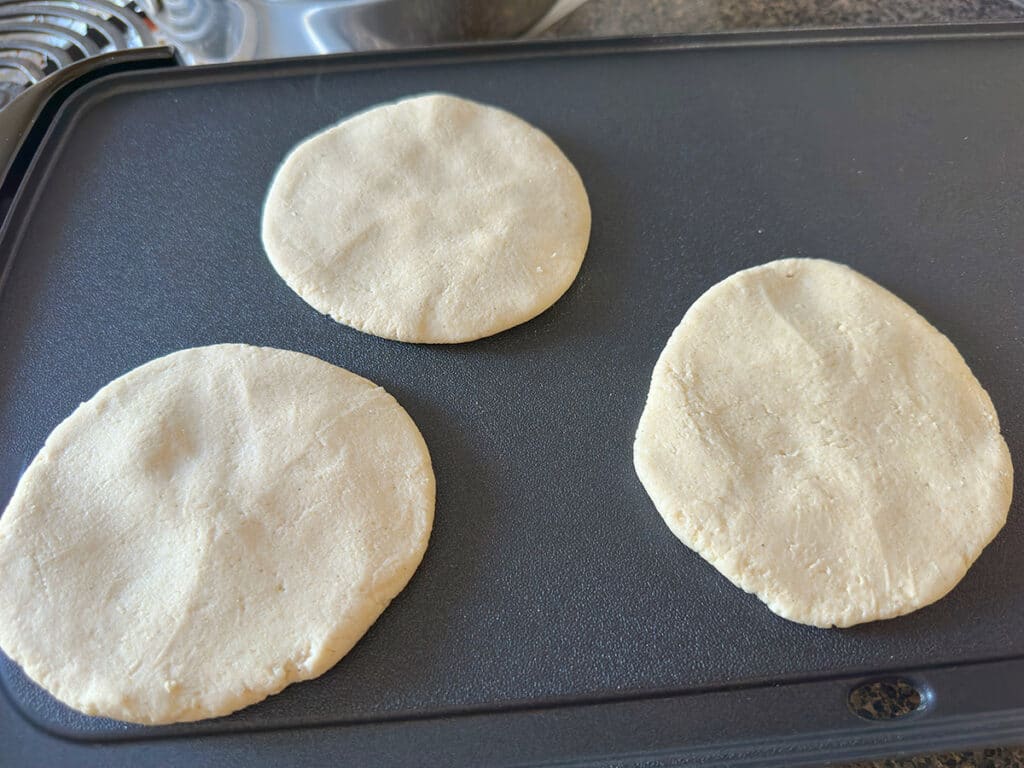 Cooking gorditas on a griddle.