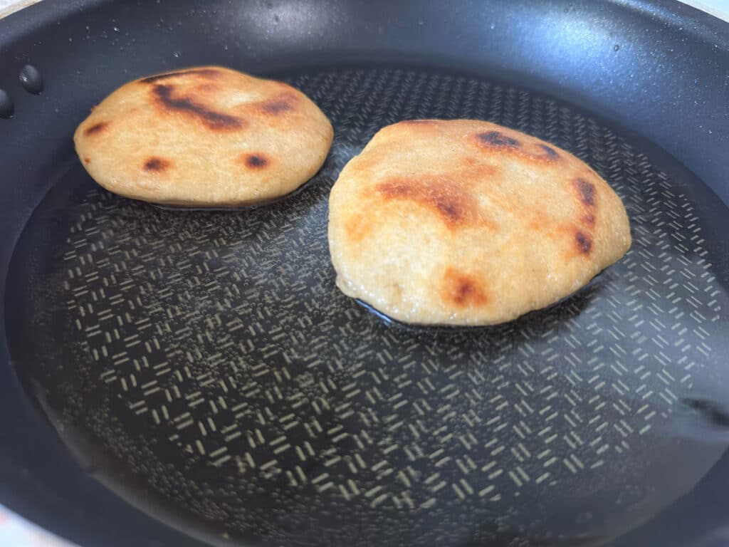 Frying gorditas in a skillet.