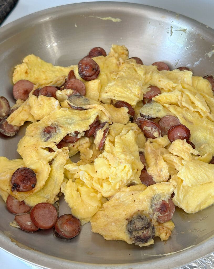 Huevos con salchicha in a pan.