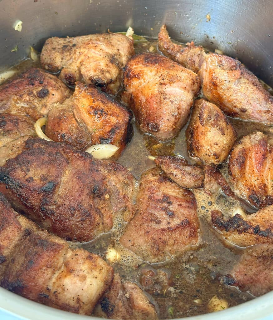 Simmering carnitas in a pot.