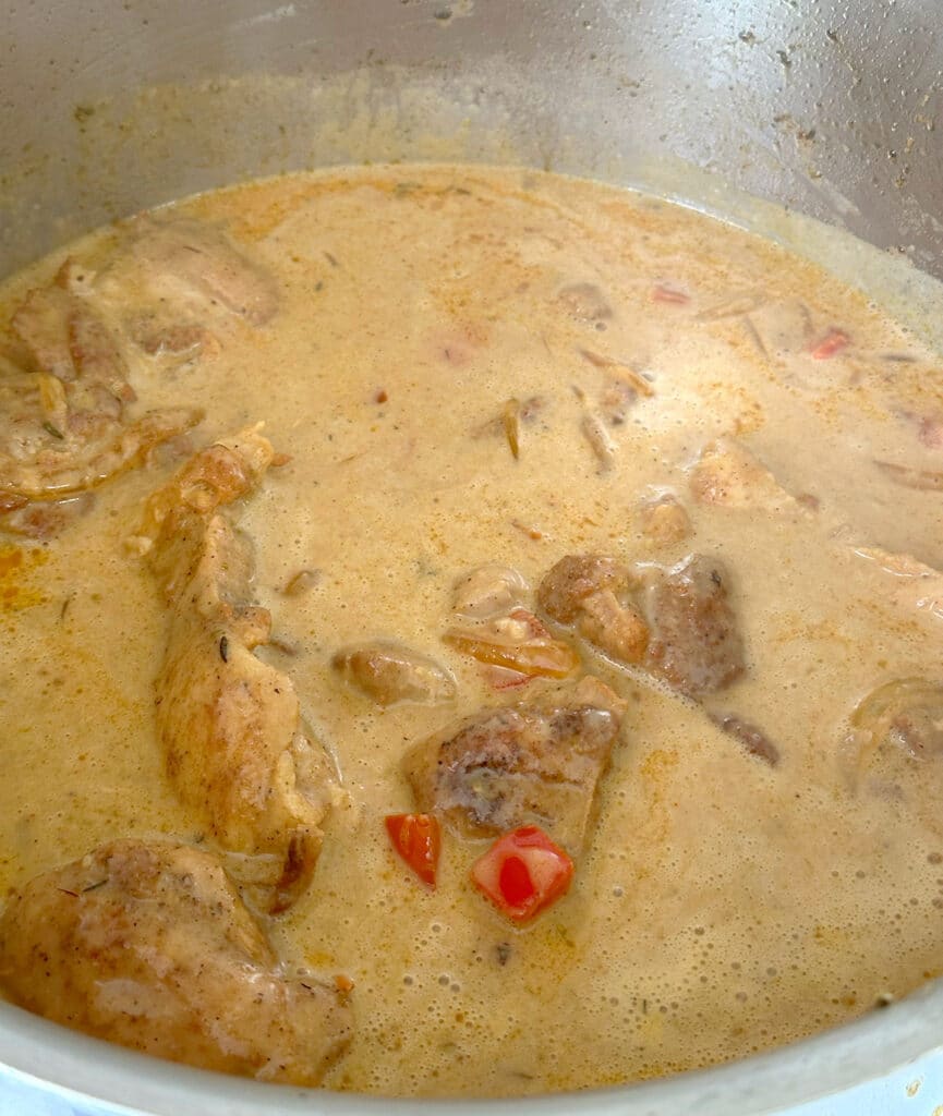 Cooking chicken and gravy in a skillet.