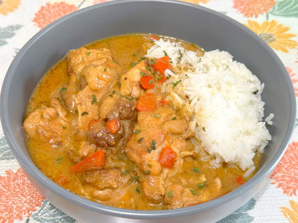 A bowl of chicken thighs and rice.