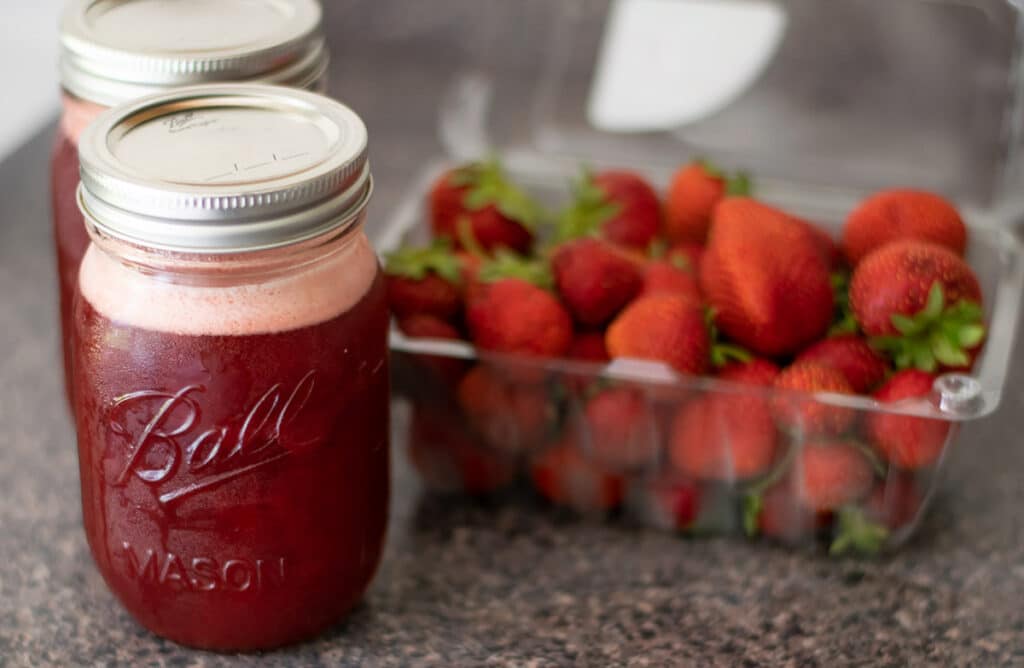 Homemade strawberry syrup in a mason jar.