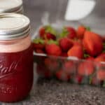 Homemade strawberry syrup in a mason jar.